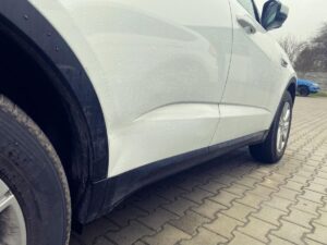 Jaguar F-Pace z uszkodzonymi drzwiami przed naprawą blacharską i lakierowaniem